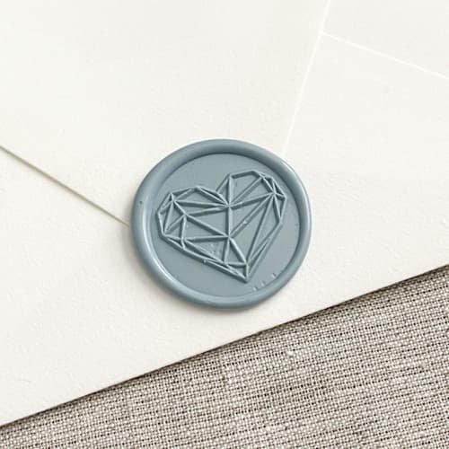 This is a blue wax seals by Orchid Studio called geometric heart self-adhesive wax seal in dusty blue | set of 10 in standard
