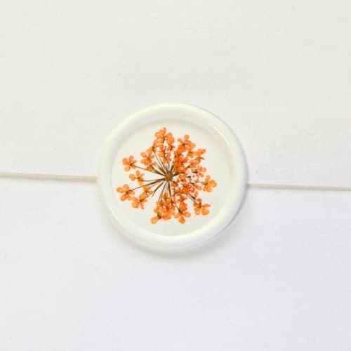This is a multicolor wax seals by Inkspiringletters called queen anne's lace- orange dried and pressed florals on white - customizable shape- set of 25 wax seals in standard