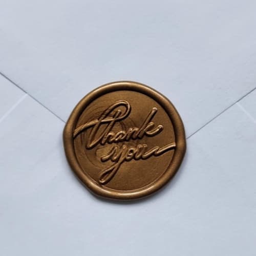 This is a gold wax seals by MC silverlinings called customizable color thank you cursive a wax seals, set of 5 in standard