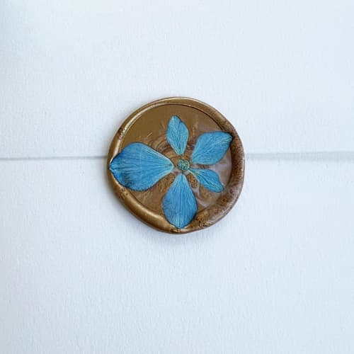 This is a blue wax seals by Caitlin Home called blue hydrangea wax seal in gold | pack of 10 in standard