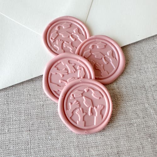 This is a pink wax seals by Orchid Studio called dusty rose graduation wax seal - graduation cap throw | set of 10 in standard