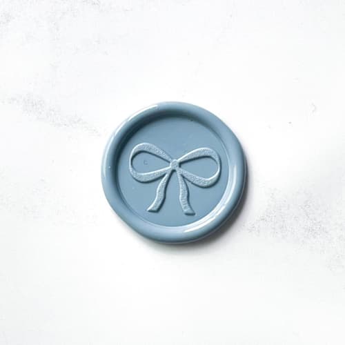 This is a blue wax seals by Abby Choi called bow wax seal in dusty blue, pack of 10 in standard