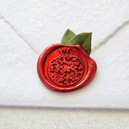 This is a red wax seals by Inkspiringletters called pomegranate with dried botanicals- hand-crafted wax seals- set of 25 in standard