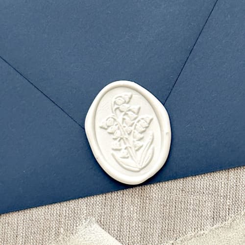This is a white wax seals by Orchid Studio called lily of the valley oval wax seal stickers in white | set of 10 in standard