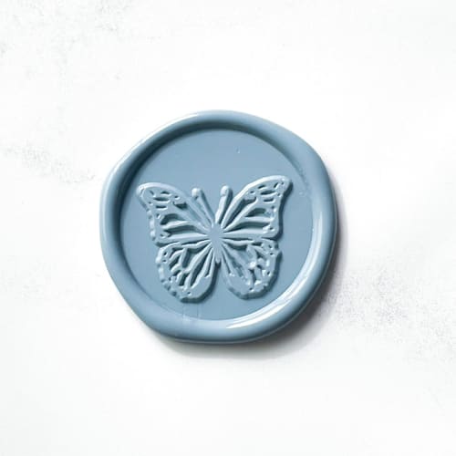 This is a blue wax seals by Abby Choi called butterfly in dusty blue, pack of 10 in standard