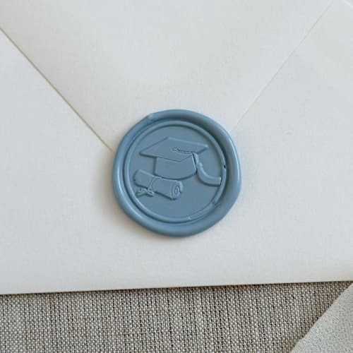 This is a blue wax seals by Orchid Studio called dusty blue graduation wax seal stickers | set of 10 in standard