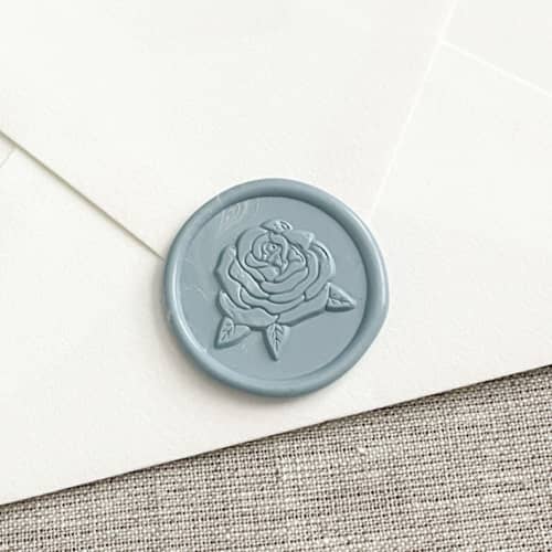 This is a blue wax seals by Orchid Studio called rose self-adhesive wax seal in dusty blue | set of 10 in standard