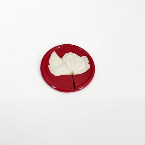 This is a red wax seals by Caitlin Home called white hydrangea wax seal in red | pack of 10 in standard