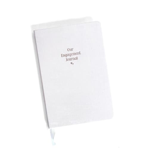 This is a beige journals by Jessica Cunningham called our engagement journal | gold foil on cream linen notebook in standard
