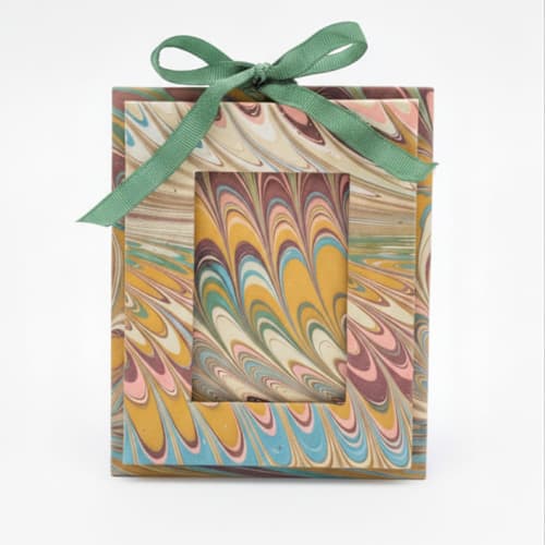 This is a multicolor holiday decorations by Inner Child called mini hand-marbled picture frame ornament | flatiron feathers in standard