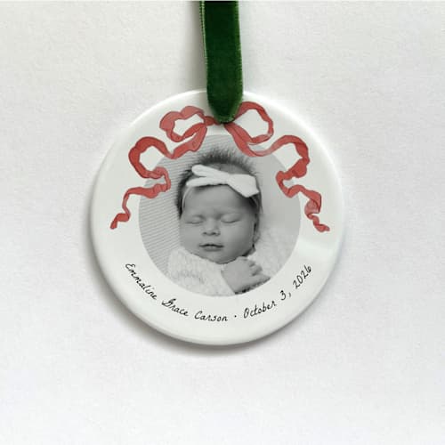 This is a white holiday decorations by Holly Whitcomb called custom ceramic photo ornament - red bow in standard