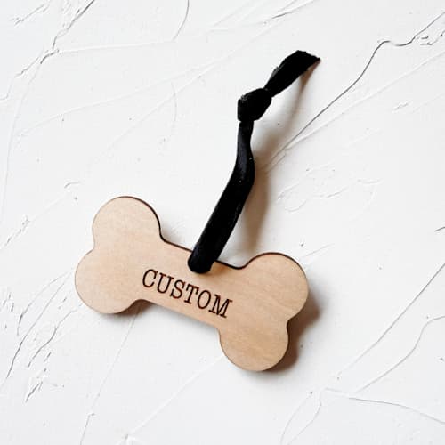 This is a beige holiday decorations by Left Grain called personalized wooden dog bone ornament in standard