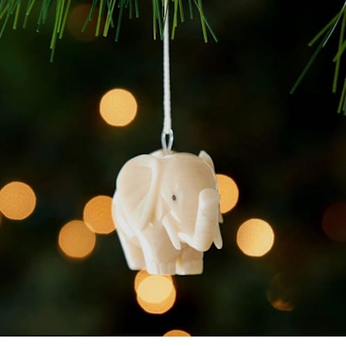 This is a beige holiday decorations by Aahlada Chennupati called mini tagua ivory elephant ornament in standard