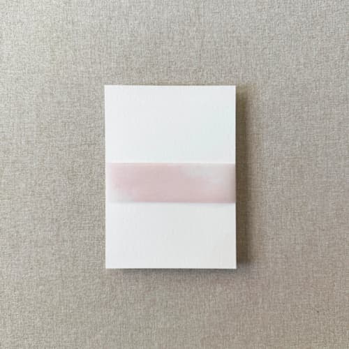 This is a pink belly bands by Cotton and Bow called blush watercolor vellum belly band | for 5x7" invitations | set of 10 in standard
