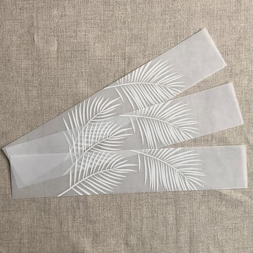 This is a white belly bands by Ivory Invitations called palm leaf white translucent vellum belly band for 5x7 card | pack of 10 in standard