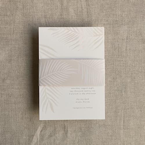 This is a beige belly bands by Ivory Invitations called palm leaf cashmere belly band for 5x7 card | pack of 10 in standard