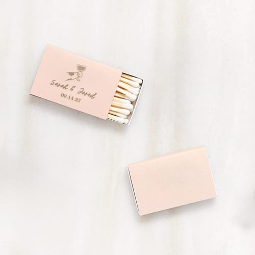 This is a beige matchbooks by ForYourParty called toasting hands wedding matchbox, set of 100 in standard