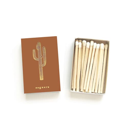 This is a brown matchbooks by Jessica Cunningham called saguaro cactus matchbox, gold on rust in standard