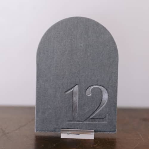 This is a gray table numbers by Velvet Raptor called double sided table number - arch - dove in standard