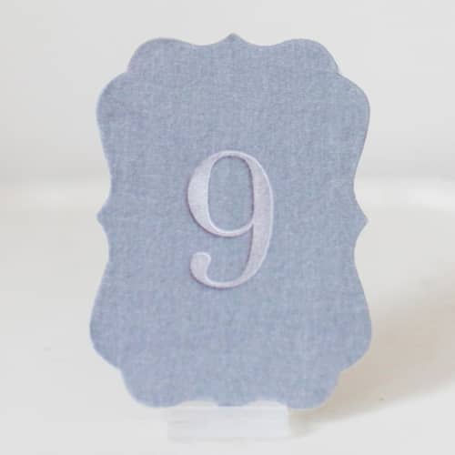 This is a gray table numbers by Velvet Raptor called scroll table number - dove in standard