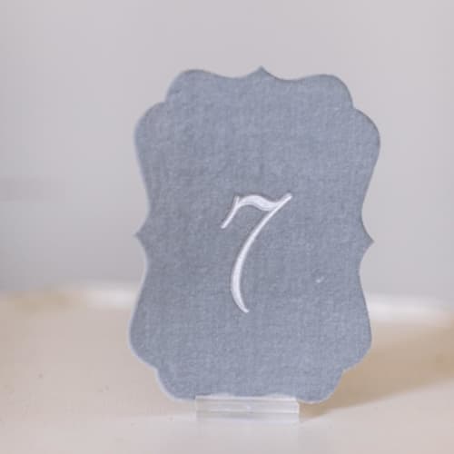 This is a gray table numbers by Velvet Raptor called dove script scroll table number in standard