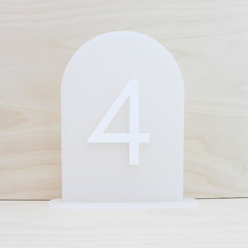 This is a white table numbers by Haven Print Co. called frosted arch table numbers set • 1-10 in standard
