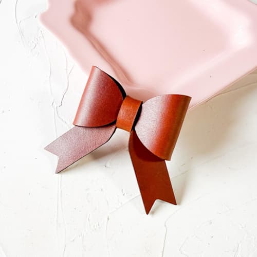 This is a brown wedding place cards by Left Grain called custom leather bow place setting, set of 2 in standard