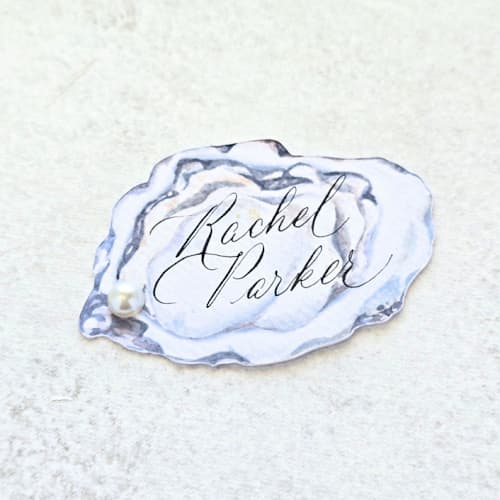 This is a white wedding place cards by Inkspiringletters called watercolor oyster with white pearl place card- personalized with calligraphy- set of 10 in standard