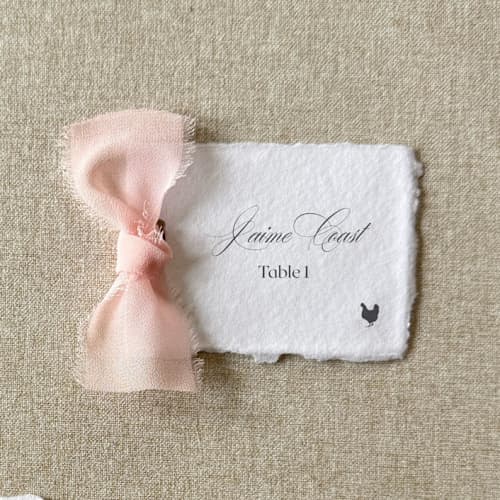 This is a pink wedding place cards by Cotton and Bow called handmade paper place cards with blush bow | set of 10 | custom text in standard