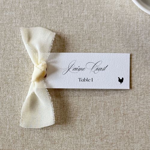 This is a white wedding place cards by Cotton and Bow called slim place cards with ivory bow | set of 10 | custom text in standard