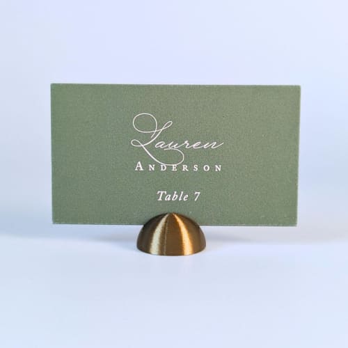 This is a brass place card holders by Corduroy Effect called brass color dome place card holders, set of 25 in standard