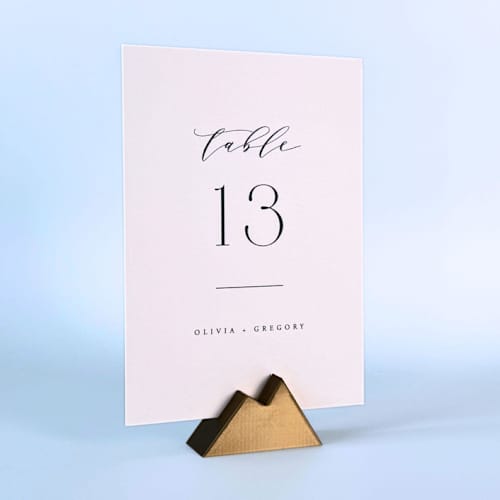 This is a brass place card holders by Corduroy Effect called brass color mountain table number holder, set of 5 in standard
