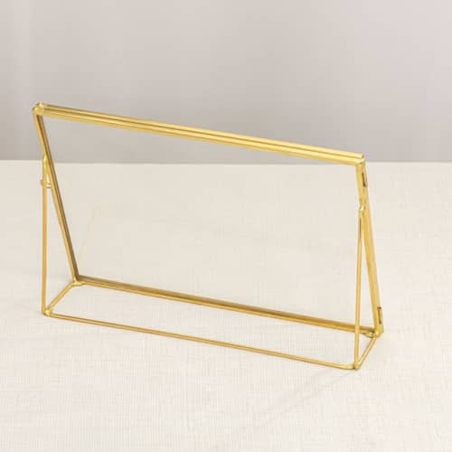 This is a gold place card holders by Lea Li called brass and glass gold horizontal 6x8" card holder in standard