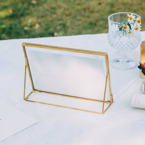 This is a brass place card holders by Lea Li called brass and glass gold horizontal 5x7" card holder in standard