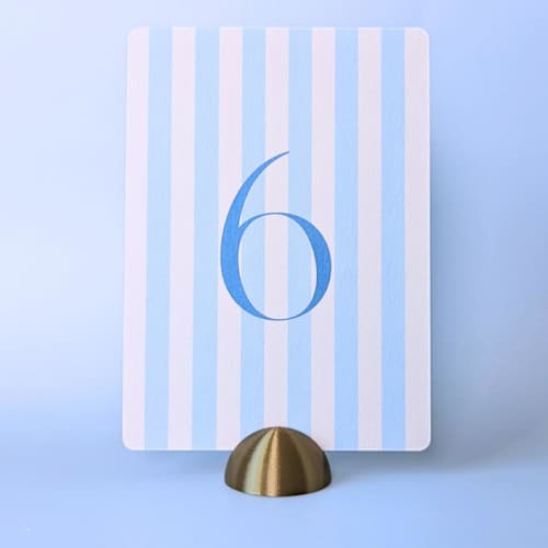 This is a brass place card holders by Corduroy Effect called brass color dome table number holders, set of 5 in standard