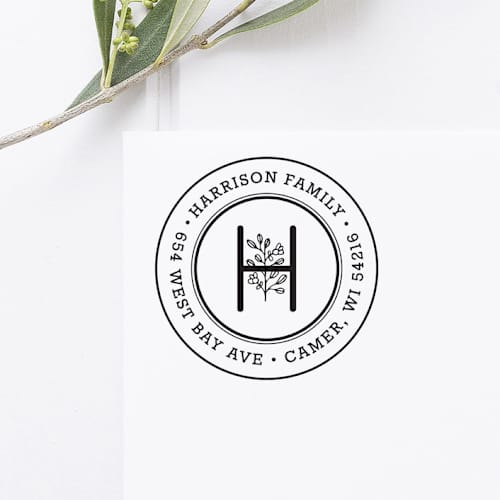 This is a black address labels by Port of Reverie called floral monogram return address stamp, round self inking in standard
