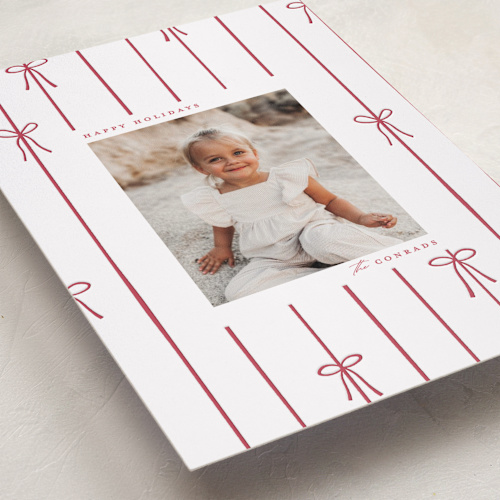 This is a cherry letterpress holiday cards with letterpress by Ellen Schlegelmilch called lines of bows printing on bright white letterpress paper in standard