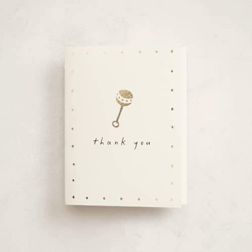 This is a cotton baby shower thank you cards with foil pressed by Stacy Maalouf called gold rattle printing on strathmore in standard