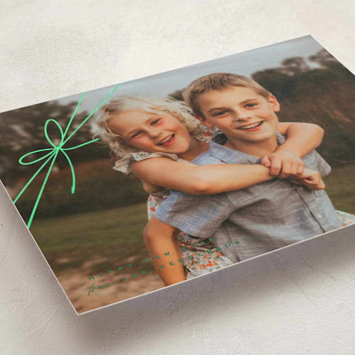 This is a juniper foil pressed holiday cards with foil pressed by Leia Matt called tied with joy printing on recycled smooth signature in standard