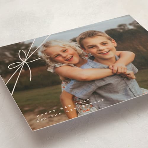 This is a woolen foil pressed holiday cards with foil pressed by Leia Matt called tied with joy printing on recycled smooth signature in standard