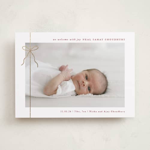 This is a cranberry babys first christmas with foil pressed by Olivia Raufman called crisp bow printing on recycled smooth signature in standard