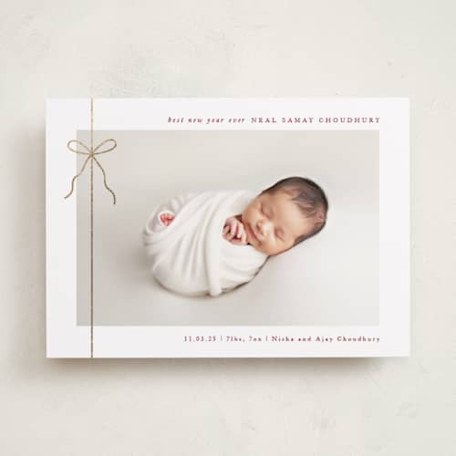 This is a cranberry babys first christmas with foil pressed by Olivia Raufman called crisp bow printing on recycled smooth signature in standard