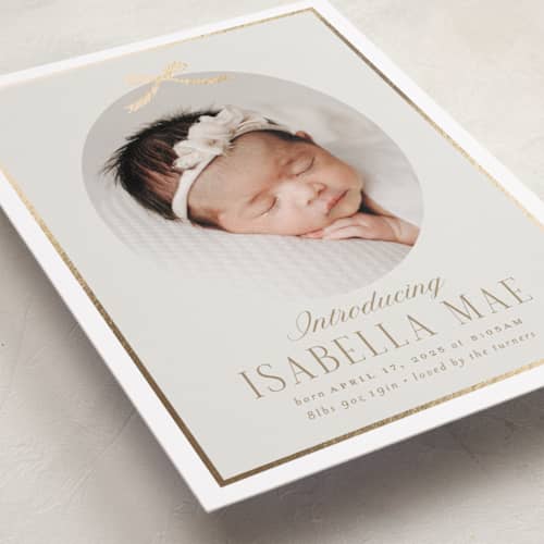 This is a cashmere foil stamped birth announcements with foil pressed by Erin German called tied with a bow printing on recycled smooth signature in standard
