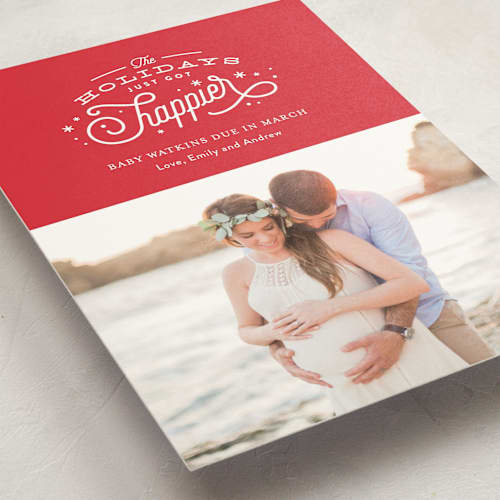 This is a poinsettia pregnancy announcements with standard by Jennifer Wick called happier holidays printing on signature in standard