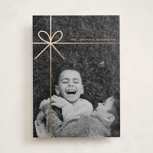 This is a champagne foil pressed holiday cards with foil pressed by Joyce Pinheiro called tied in cheer printing on recycled smooth signature in standard