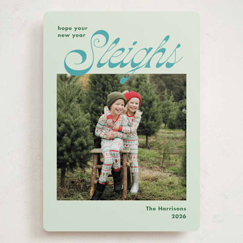 This is a turquoise holiday photo cards with standard by Megan Davis called sleighs printing on recycled smooth signature in grand