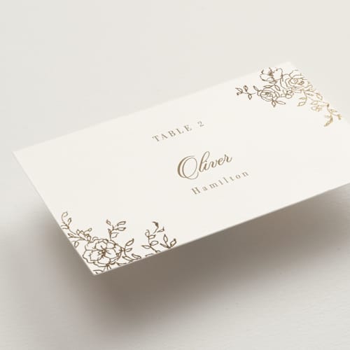 This is a champagne wedding place cards with foil pressed by Cass Loh called floral crest printing on signature in placecard