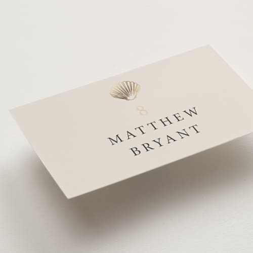 This is a sand wedding place cards with foil pressed by Hannah Bowman called simple seashell printing on signature in placecard