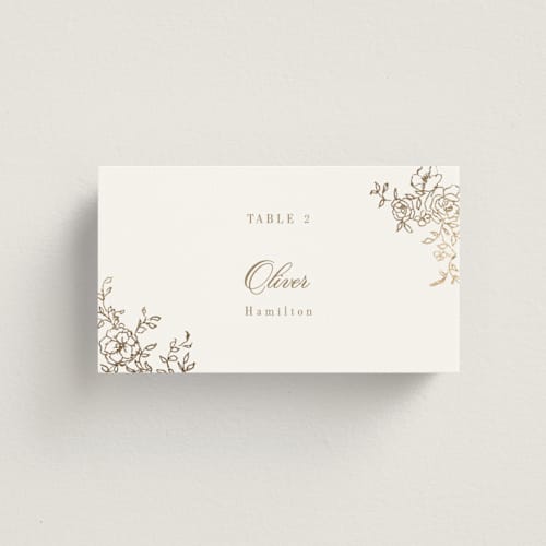 This is a champagne wedding place cards with foil pressed by Cass Loh called floral crest printing on signature in placecard