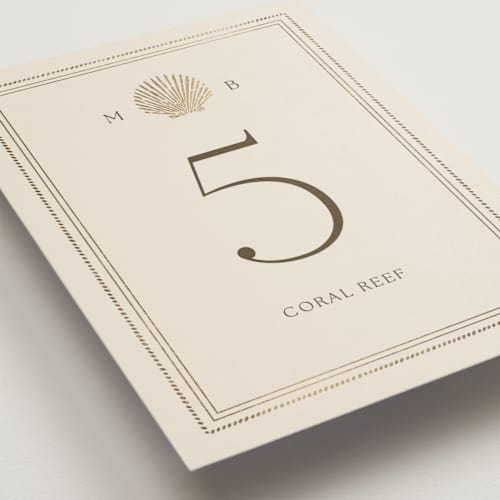 This is a champagne table numbers with foil pressed by Griffinbell Paper Co. called seaside printing on doublethick in standard
